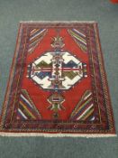 A Caucasian rug on red ground,