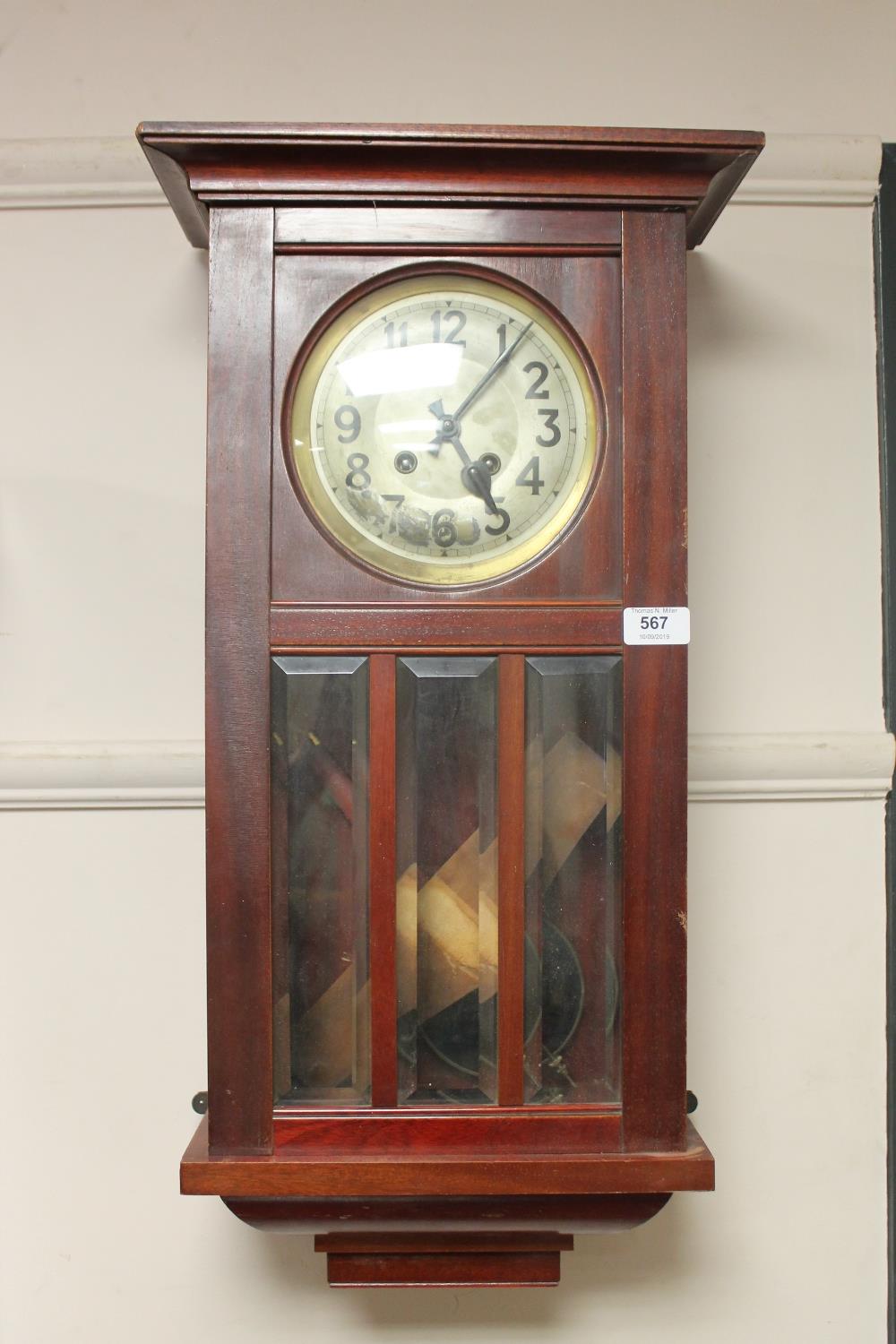 A mahogany wall clock with silvered dial,