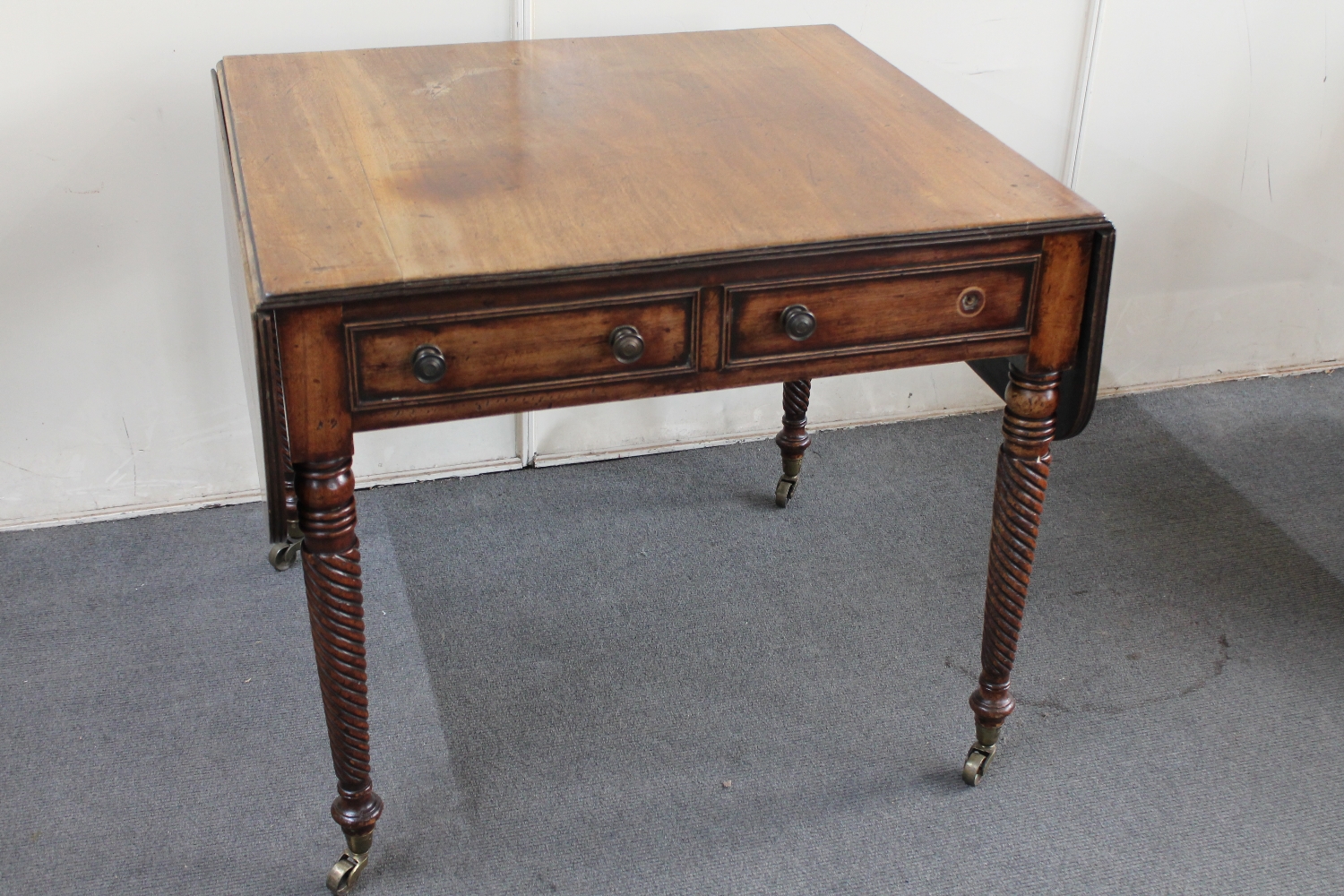 A 19th century mahogany flap sided table on turned legs