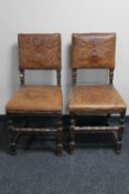 A pair of antique oak embossed leather dining chairs