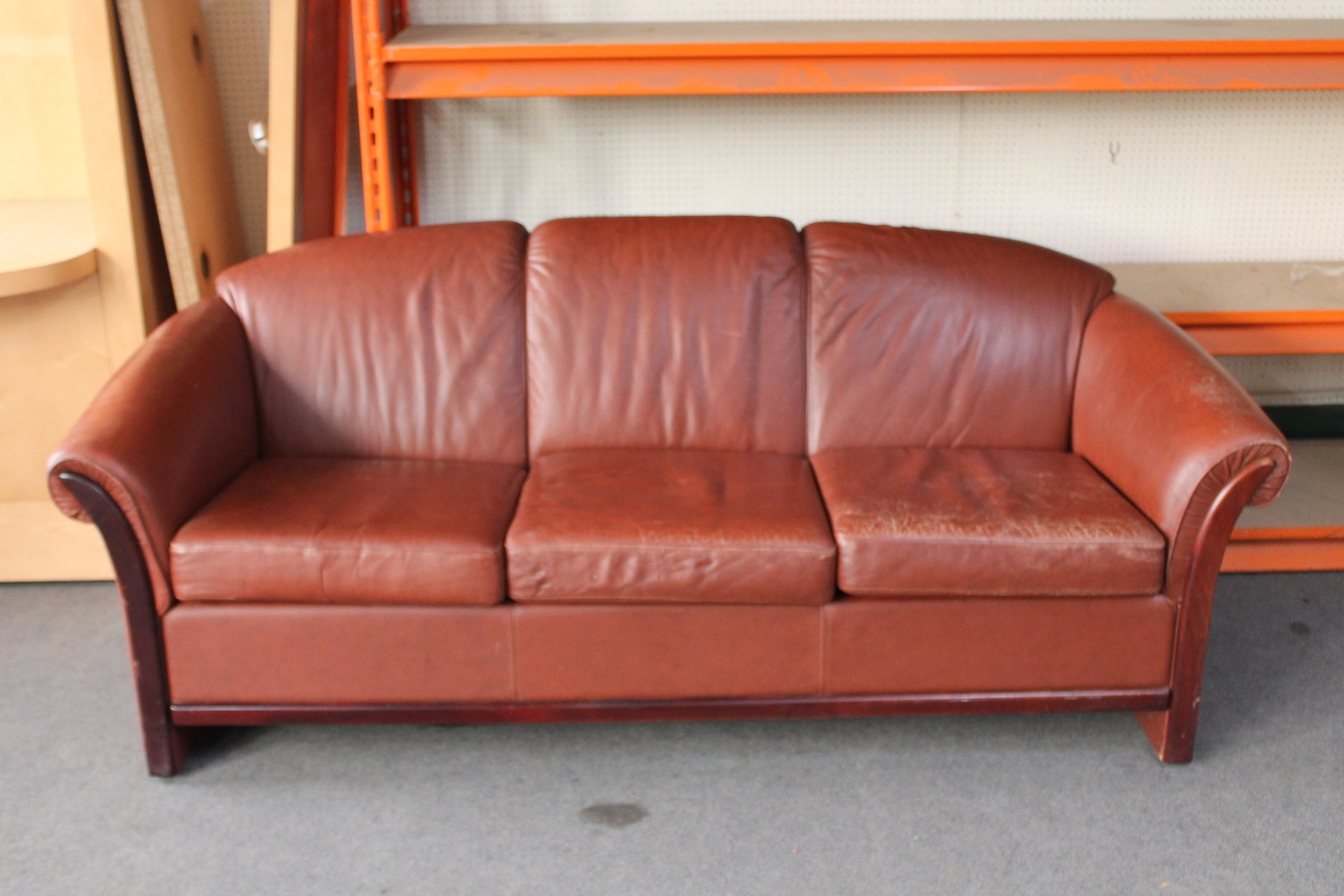 A Danish stained beech framed three seater settee in brown leather