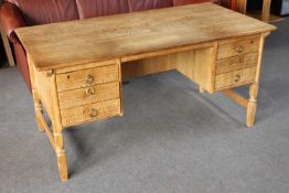 A blonde oak writing desk fitted six drawers