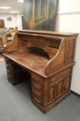 An early 20th century oak roll top desk,