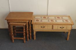 A nest of three blonde oak tables and a tiled topped low table