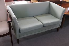 A late 20th century two seater settee in green fabric