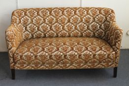 A 20th century two seater settee in gold floral brocade