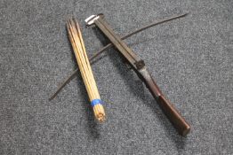 An antique crossbow and a bundle of arrows
