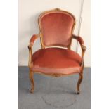 A carved beech framed salon armchair in pink dralon