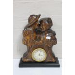 An antique carved West German black forest style figural mantel clock