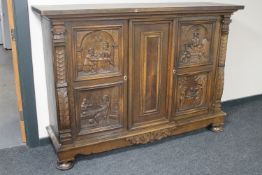 A continental carved oak sideboard on bun feet