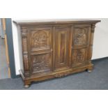 A continental carved oak sideboard on bun feet