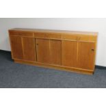 A mid 20th century teak sliding door bookcase fitted three drawers above CONDITION
