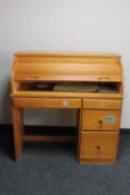 A contemporary pine roll top desk