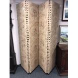 An early 20th century four fold screen in studded floral fabric
