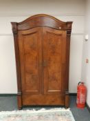 A walnut dome top double wardrobe,