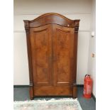 A walnut dome top double wardrobe,