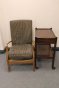 A teak framed armchair and a two tier trolley