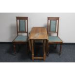 A pair of early 20th century oak high back dining chairs and gate leg table