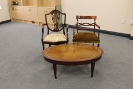 An oval mahogany coffee table and two mahogany armchairs