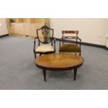 An oval mahogany coffee table and two mahogany armchairs