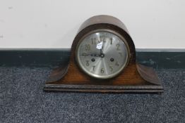 An early 20th century oak cased mantel clock with silvered dial