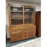 A Barker & Stonehouse hardwood sliding door bookcase fitted cupboards beneath,