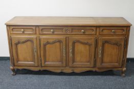 A contemporary walnut four door sideboard fitted three drawers