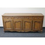 A contemporary walnut four door sideboard fitted three drawers