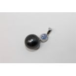 A 14ct white gold pearl and diamond pendant featuring one cultured Tahitian pearl with one oval cut