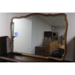 A shaped walnut framed overmantel mirror
