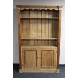 A set of antique pine bookshelves fitted with cupboards beneath