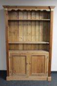 A set of antique pine bookshelves fitted with cupboards beneath