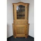 A blond oak leaded glass door corner display cabinet