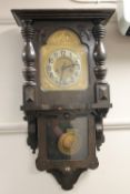 An antique oak cased wall clock with brass dial,