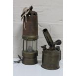 An antique converted miner's lamp and a vintage brass blow lamp
