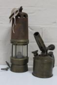 An antique converted miner's lamp and a vintage brass blow lamp