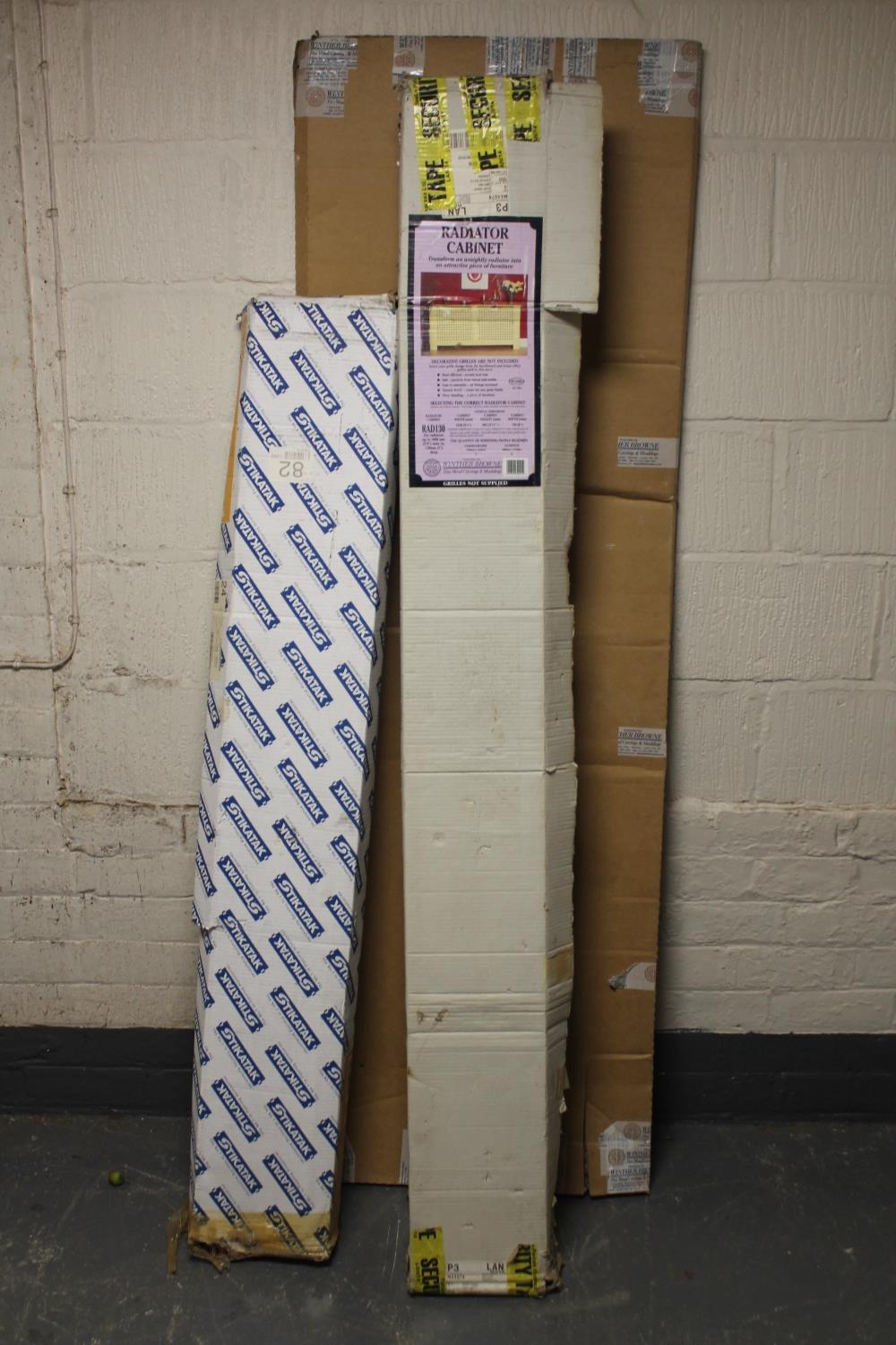 A box of carpet grip rods together with a flat packed radiator cabinet