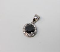 A 14ct white gold black diamond pendant featuring one round brilliant cut natural black diamond 1.