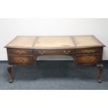 A mahogany five drawer writing desk on claw and ball feet
