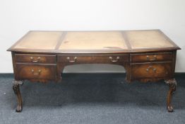 A mahogany five drawer writing desk on claw and ball feet