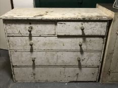 An antique painted pitch pine five drawer chest