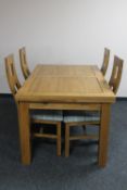 A contemporary oak extending dining table and four high back chairs