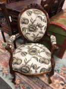 A Victorian carved walnut armchair in floral upholstery,