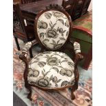 A Victorian carved walnut armchair in floral upholstery,