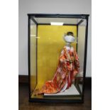 A counter top display cabinet containing a Geisha