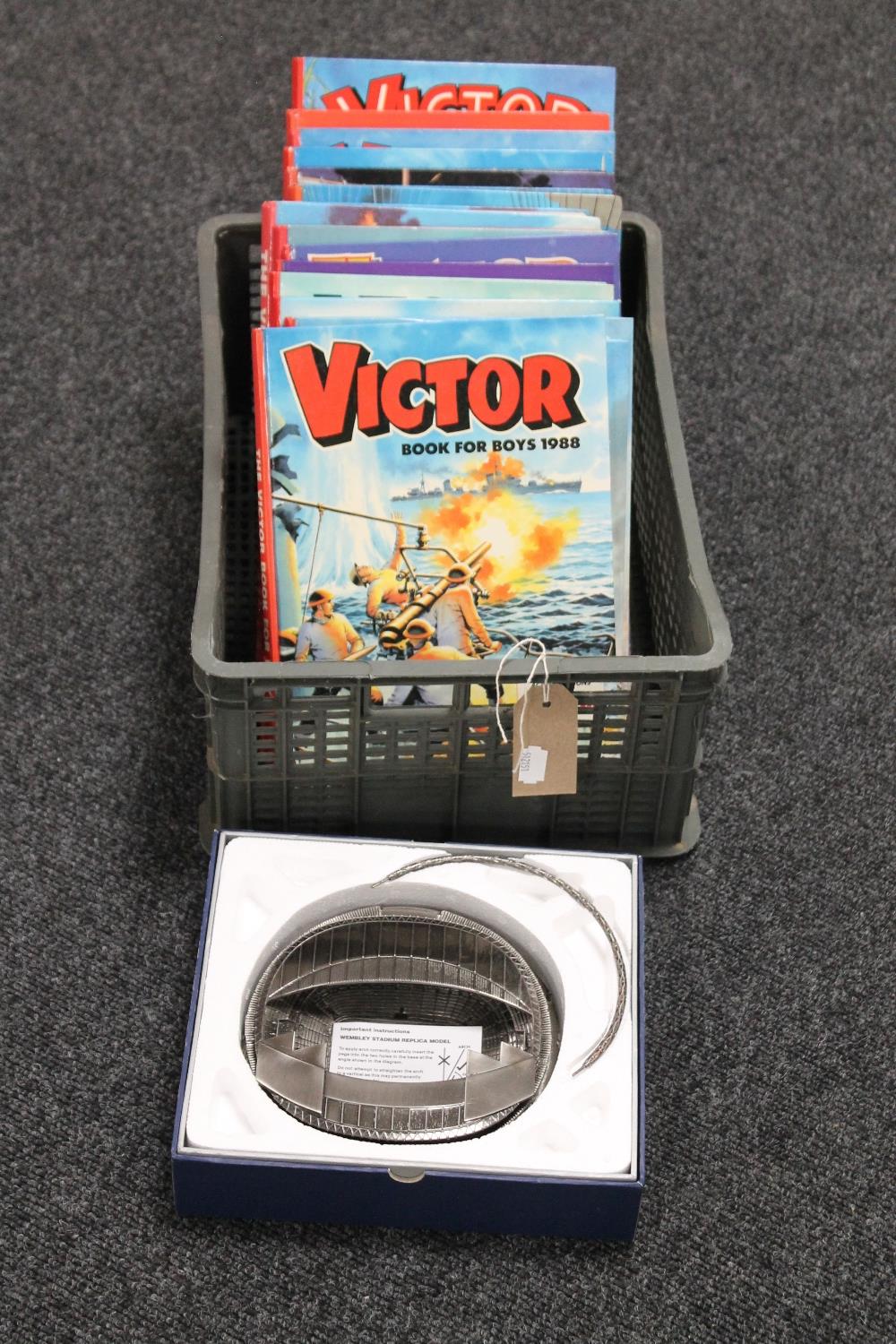 A crate of fifteen 1980/1990's Victor for boys annuals and a Wembley stadium metal model