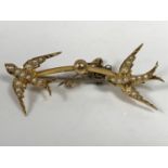 A 15ct gold swallow brooch set with seed pearls