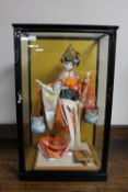 A counter top display cabinet containing a Geisha carrying two water buckets