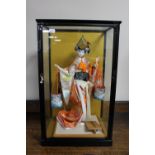 A counter top display cabinet containing a Geisha carrying two water buckets