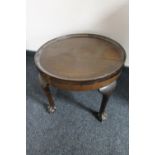 A circular walnut coffee table on claw and ball feet